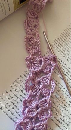 the crochet is laying on top of an open book