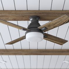 a ceiling fan that is on top of a wooden beam in a room with white walls