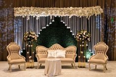 an elaborately decorated stage set up for a wedding reception with white flowers and greenery