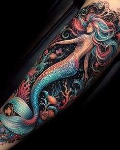 a woman's arm with a colorful mermaid tattoo on it