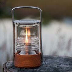 a lit candle sitting on top of a piece of wood