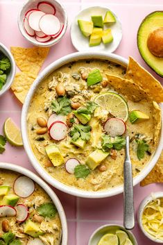 bowls of soup with tortilla chips, avocado and radishes