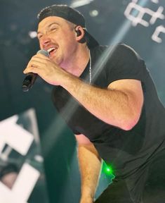 a man singing into a microphone on stage