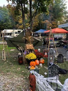 halloween decorations and pumpkins are on display in the grass at an outdoor event with tents