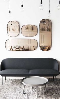 a living room filled with furniture and mirrors hanging on the wall above it's headboard