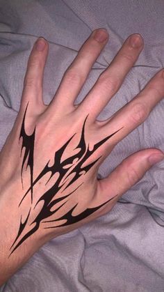 a person's hand with black ink on it and an abstract design in the middle