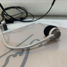 a close up of a microphone on top of a white surface with wires attached to it