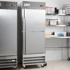 two stainless steel refrigerators sitting in a kitchen next to shelves with food on them