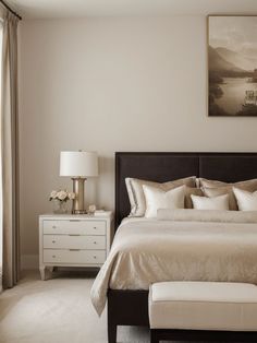 a bedroom with a large bed and two nightstands next to a painting on the wall