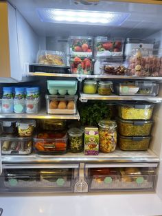 an open refrigerator filled with lots of food and condiments in containers on the shelves