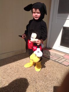 a little boy dressed in mickey mouse costume