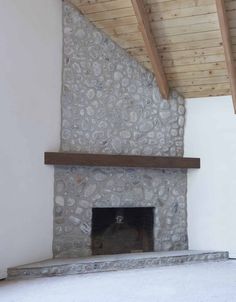 a stone fireplace in a room with wood beams