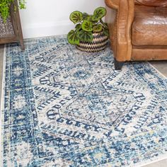 a blue and white area rug with a brown chair next to it