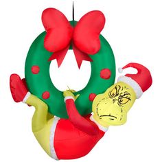 an inflatable christmas ornament hanging from a tree with a wreath on it