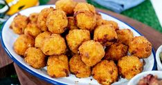 fried food on a plate with dipping sauces next to it and a bowl of dip