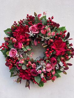 a wreath with red flowers and green leaves