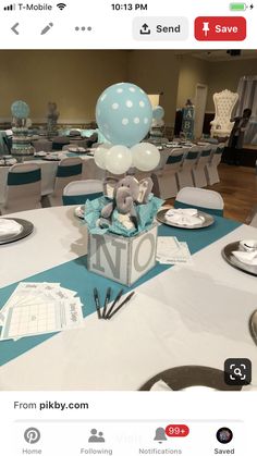 the table is set up for a baby shower with blue and white decorations on it