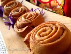 several cinnamon rolls on a wooden cutting board