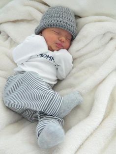 a baby is sleeping on a blanket wearing a hat