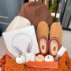 a pile of items sitting on top of a blanket next to a brown bag and some shoes