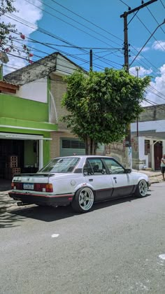 a white car parked in front of a green building