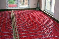 a room filled with lots of red pipes in front of two windows and a window sill