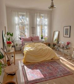 a bed room with a neatly made bed next to two windows and a rug on the floor