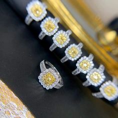 five different rings sitting on top of a black table next to a gold and white object