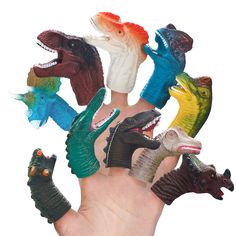 a hand is holding several small toy dinosaurs