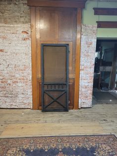 an old wooden door with a screen in the middle and a rug on the floor next to it