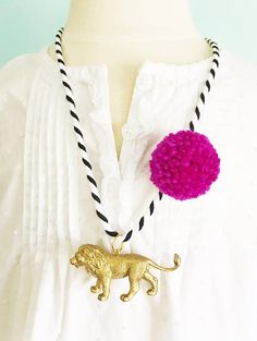 {ITEM DESCRIPTION}Handmade using recycled plastic animal toys and painted in gold then sealed with care. Each necklace is made using a soft, black and white cotton cording and accented with a trendy, bright 1" yarn pompom.  Necklace measures about 24" and can be secured with a child-safe, CPSIA compliant plastic break-away clasp or slipped over your child's head.  Animal charm measures approximately 1.5" long and 1" tall.  {MEASUREMENTS}Necklace measures about 24" long. Easy for kids to put on t Pompom Necklace, Pom Pom Necklace, Lion Necklace, Gold Lion, Animal Toys, Circus Party, Pet Necklace, Plastic Animals, Rainbow Unicorn