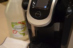 a close up of a coffee maker with a bottle of water next to it on a counter