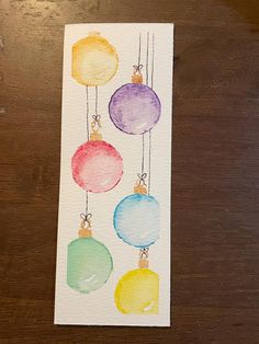 watercolor christmas ornament cards on a wooden table