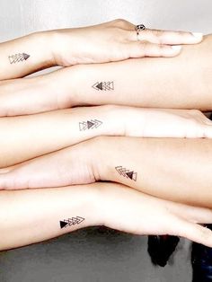 three women with matching tattoos on their arms are holding onto each other's hands