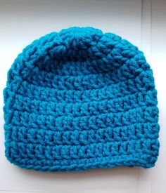 a blue crocheted hat sitting on top of a table