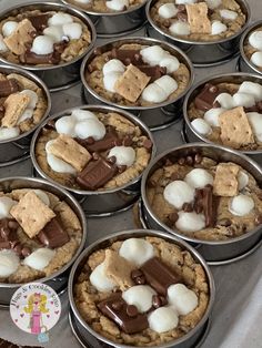 several tins filled with cookies and marshmallows on top of each other