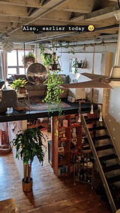 an image of the inside of a house with plants on it and stairs leading up to the second floor