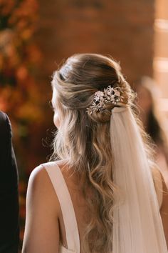 a bride with her hair in a half - up braid wearing a bridal veil