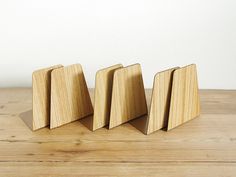 three wooden bookends sitting on top of a wooden table