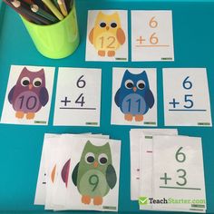 an assortment of owl themed number cards on a blue table with pencils and markers