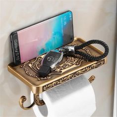 a cell phone is sitting on top of a toilet paper holder with a charger attached to it