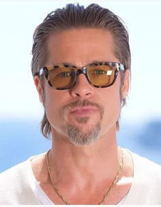 a man with long hair and sunglasses looking at the camera