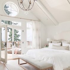 a large white bed sitting inside of a bedroom