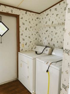 a washer and dryer in a small room with wall paper on the walls