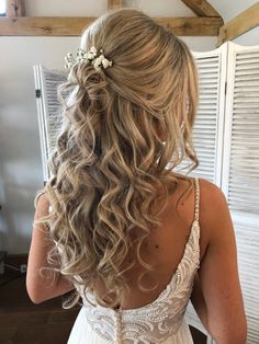 the back of a woman's head with long hair and flowers in her hair