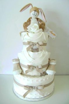 a stuffed rabbit sitting on top of a diaper cake