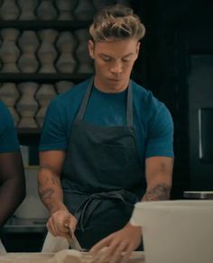 two men in aprons are preparing food together