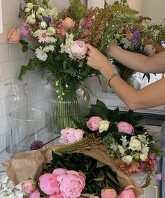 a woman is arranging flowers in a vase