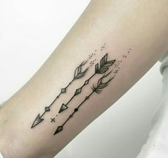 a woman's arm with an arrow and arrows tattoo on the left inner forearm