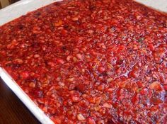 a pan filled with red food sitting on top of a wooden table